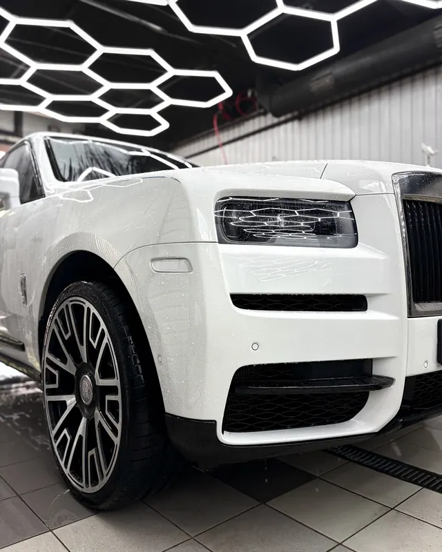Белый Rolls-Royce Cullinan в боксе под сотами