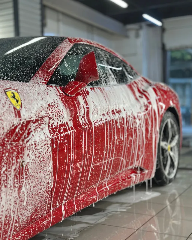Красный Ferrari в пене сбоку